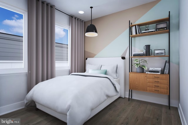 bedroom with multiple windows, wood finished floors, and baseboards