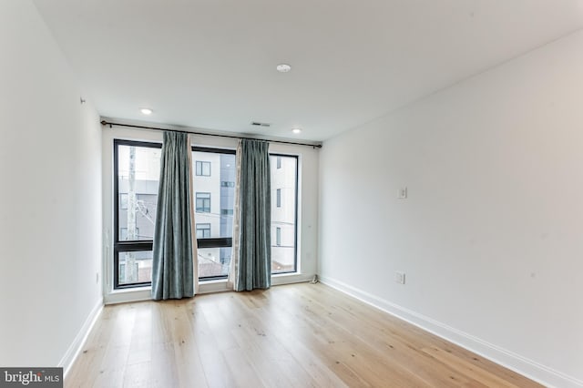 empty room with baseboards and light wood-style flooring
