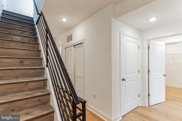 staircase featuring recessed lighting, wood finished floors, visible vents, and baseboards