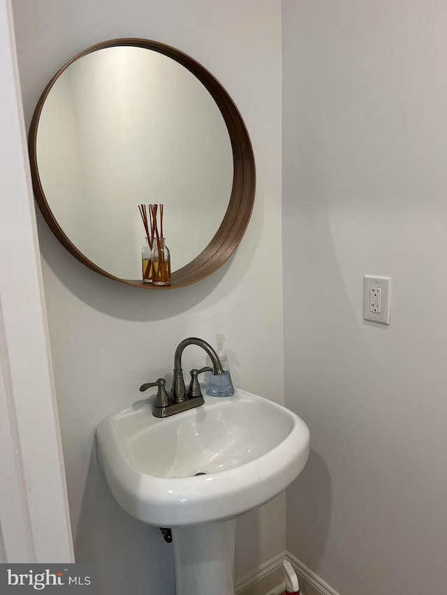 bathroom featuring baseboards and a sink