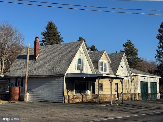 3484 Kitzmiller Rd, Kitzmiller, MD 21538 - view of front facade featuring stone siding, roof with shingles, and a chimney