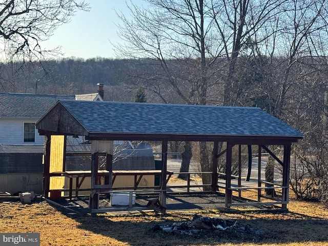 exterior space featuring a gazebo and a view of trees