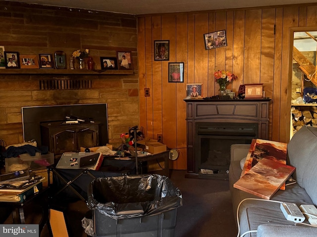 living room with wood walls and a fireplace