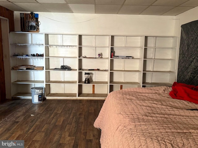 unfurnished bedroom with a drop ceiling and dark wood-type flooring