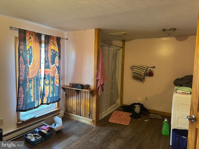 bathroom with visible vents, baseboards, a stall shower, wood finished floors, and a textured ceiling