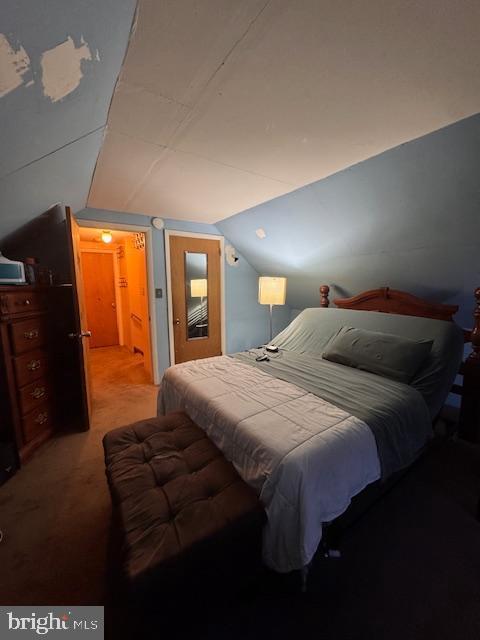 bedroom with light carpet and vaulted ceiling