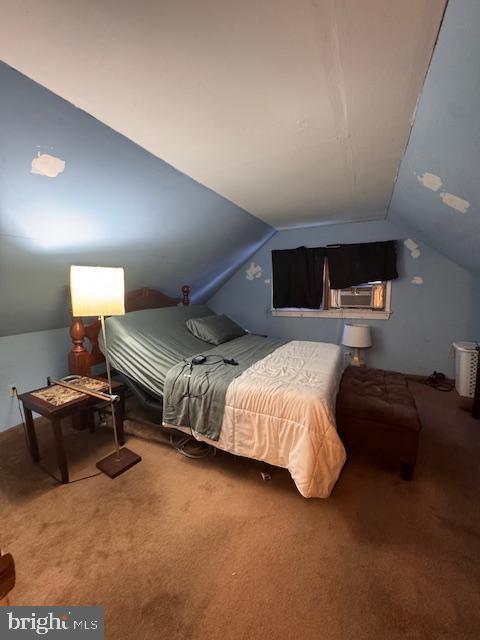 bedroom featuring lofted ceiling and carpet