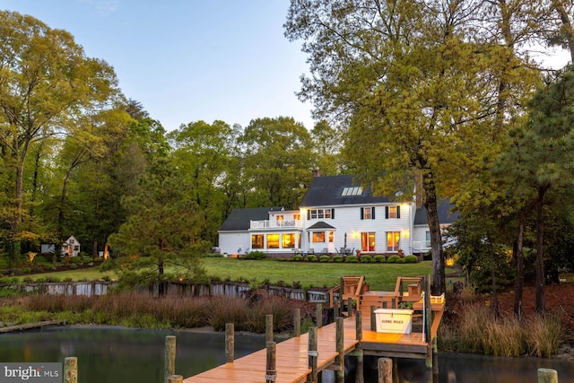 back of property with a yard and a water view