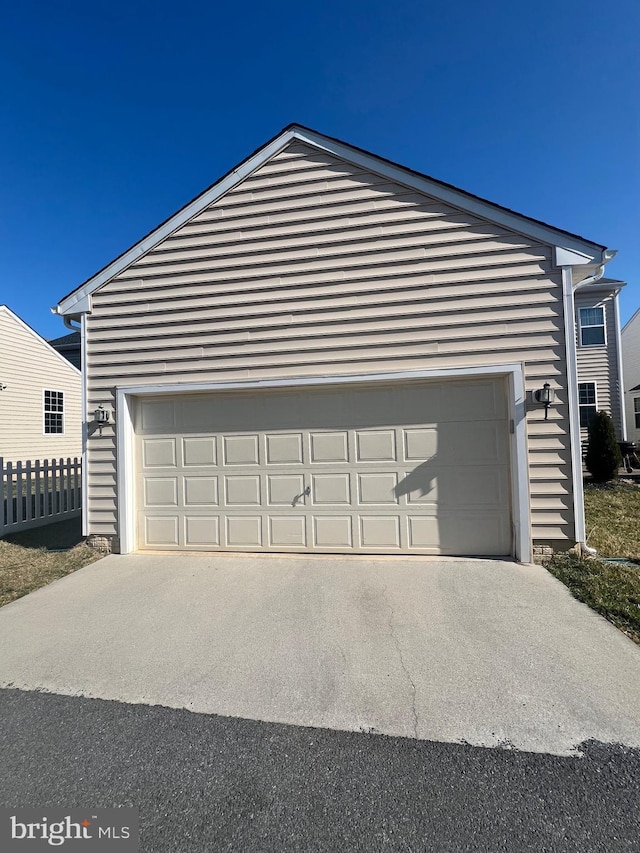 garage with driveway and fence