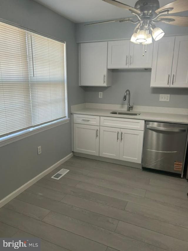 kitchen featuring a sink, visible vents, stainless steel dishwasher, and white cabinets