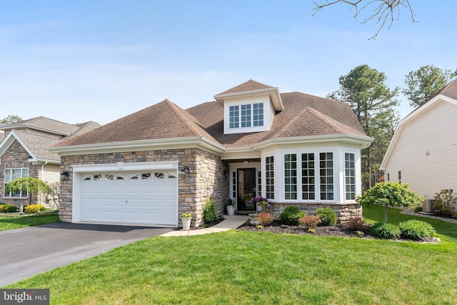view of front facade with a front lawn, aphalt driveway, stone siding, roof with shingles, and an attached garage