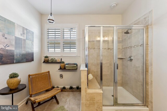 bathroom featuring baseboards, a shower stall, and tile patterned flooring