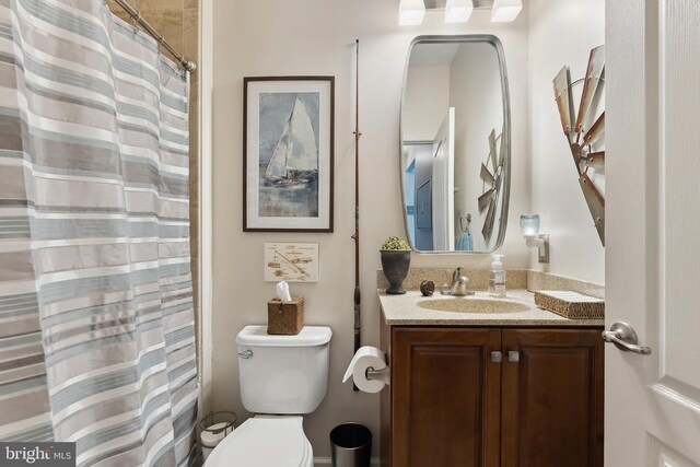 bathroom with toilet, a shower with shower curtain, and vanity