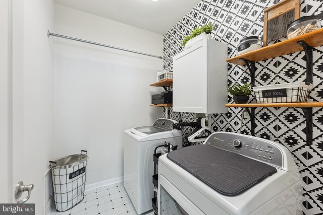 laundry room featuring laundry area, washing machine and dryer, baseboards, and light floors