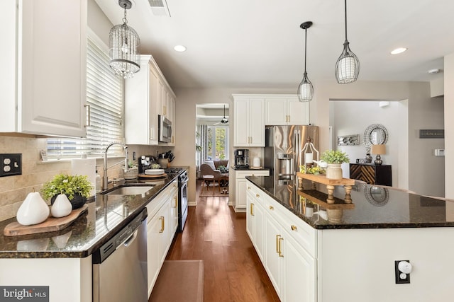 kitchen with visible vents, white cabinetry, a sink, dark wood finished floors, and appliances with stainless steel finishes