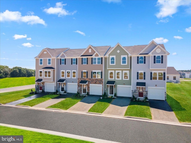 multi unit property with board and batten siding, a front yard, driveway, stone siding, and an attached garage