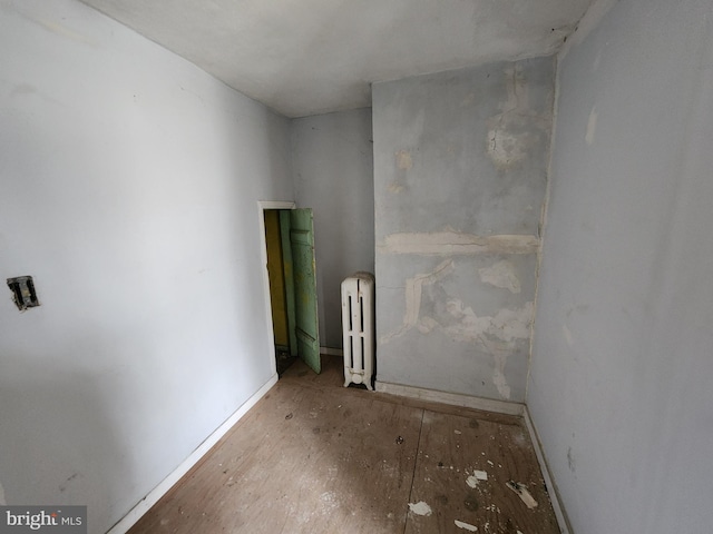 unfurnished room featuring radiator heating unit