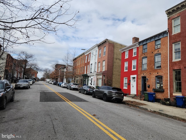 view of road with sidewalks, a residential view, and curbs