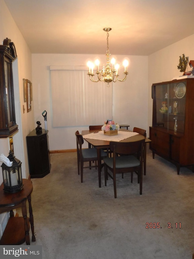 dining room with light colored carpet and a chandelier