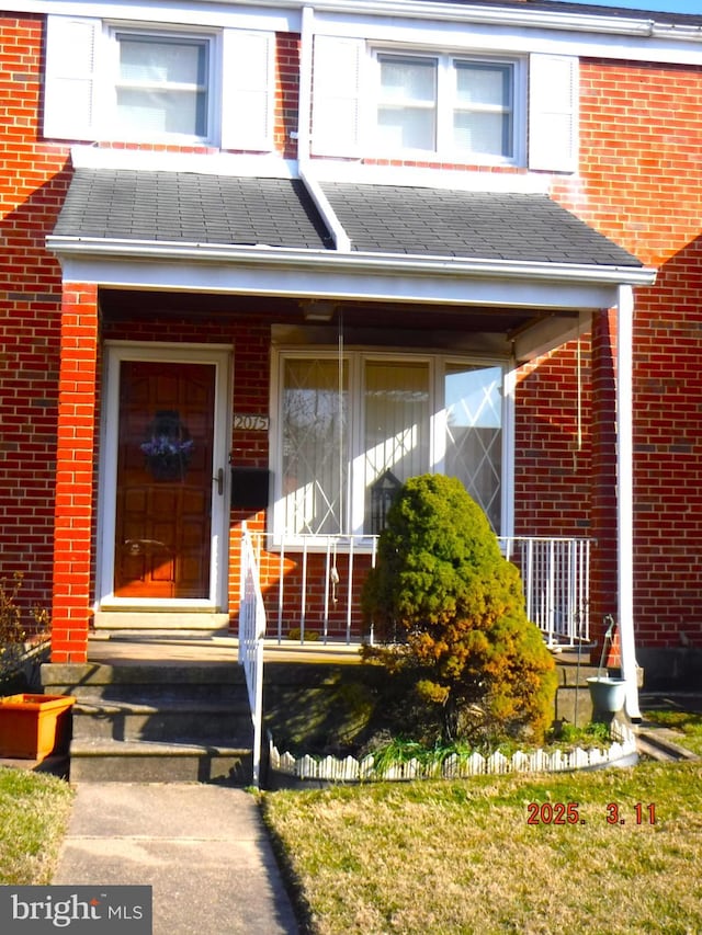 entrance to property featuring brick siding