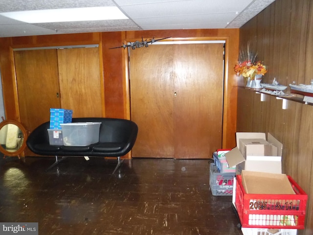 interior space with wood walls and a paneled ceiling