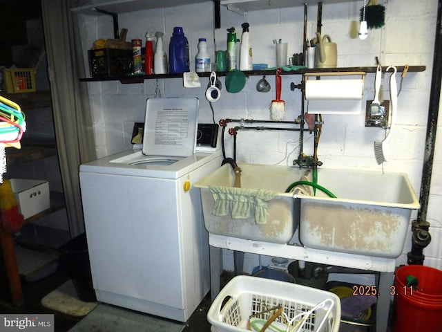 washroom featuring laundry area, washer / clothes dryer, and concrete block wall