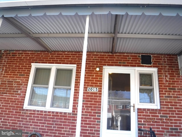 property entrance featuring brick siding