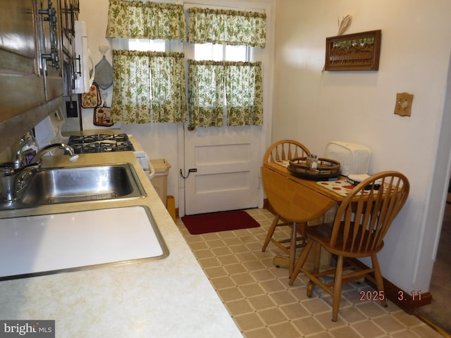 kitchen with tile patterned floors, light countertops, and a sink