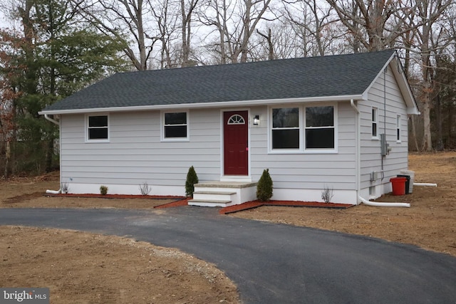 view of front facade with driveway and roof with shingles