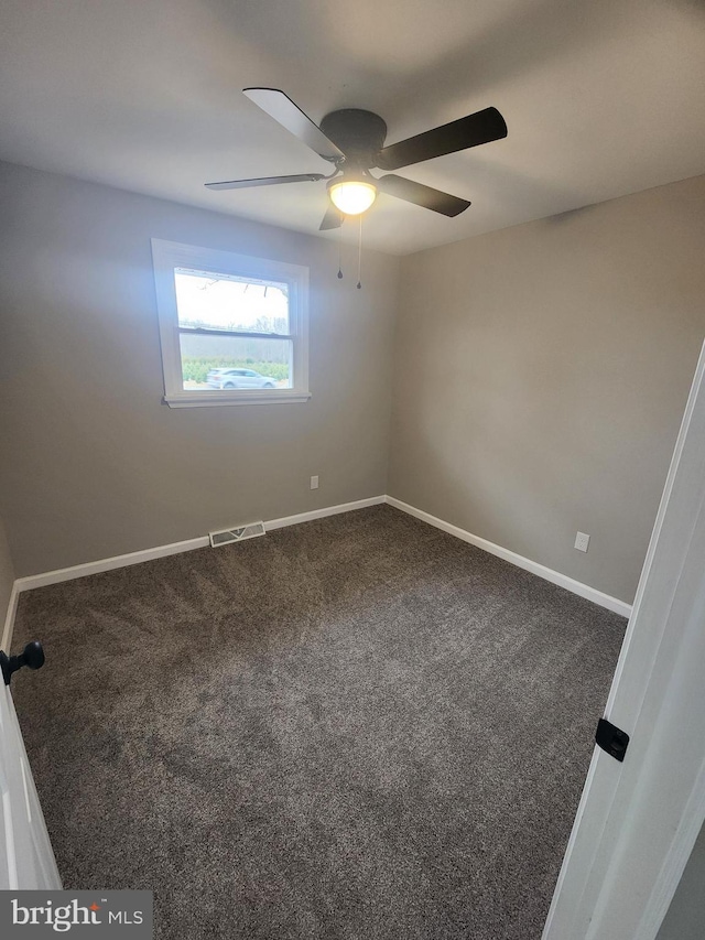 carpeted spare room featuring visible vents, baseboards, and ceiling fan