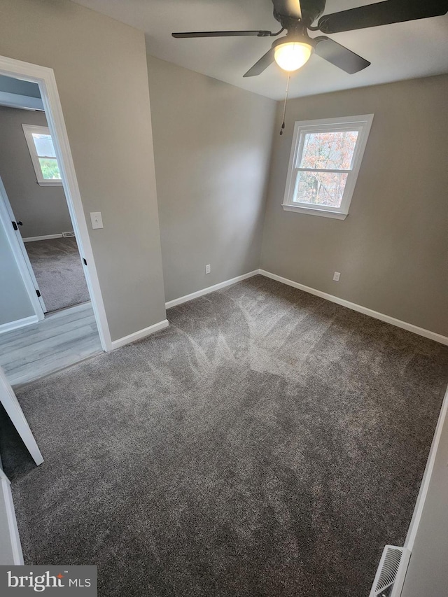 unfurnished bedroom featuring visible vents, ceiling fan, baseboards, and carpet