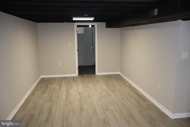 finished below grade area featuring baseboards and light wood-style flooring