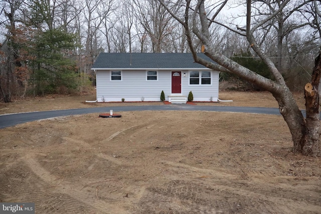 ranch-style home with entry steps and a shingled roof