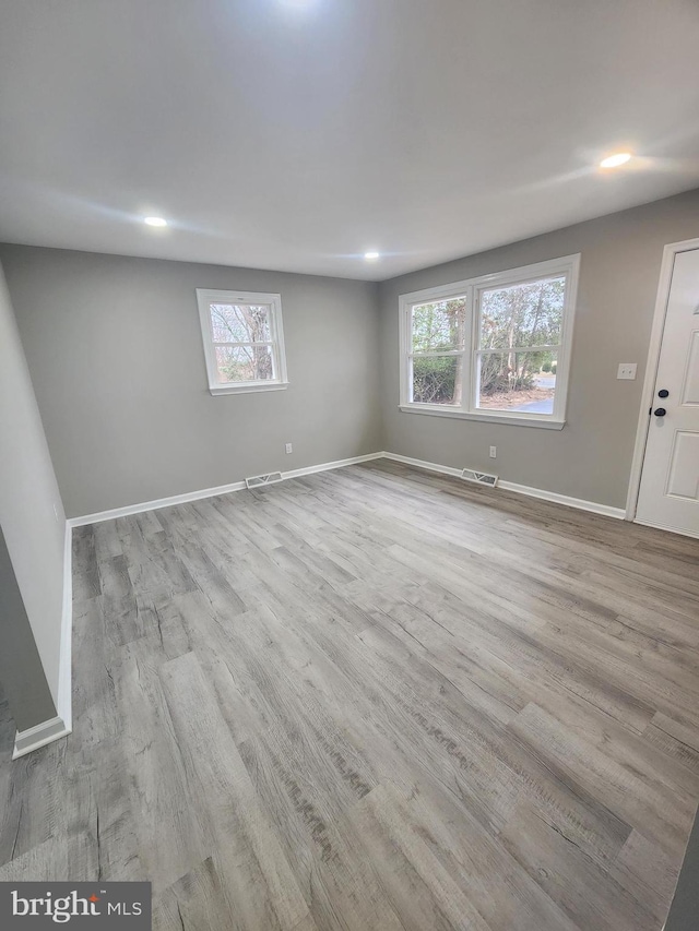 unfurnished room with visible vents, recessed lighting, baseboards, and wood finished floors