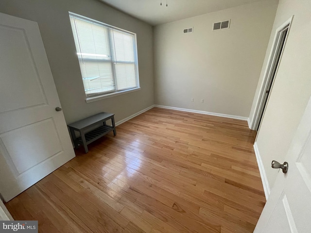 unfurnished bedroom with light wood finished floors, visible vents, and baseboards