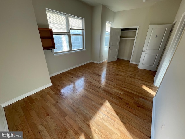 unfurnished bedroom with light wood finished floors, a closet, and baseboards