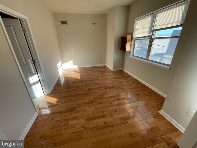 interior space featuring visible vents, baseboards, and wood finished floors