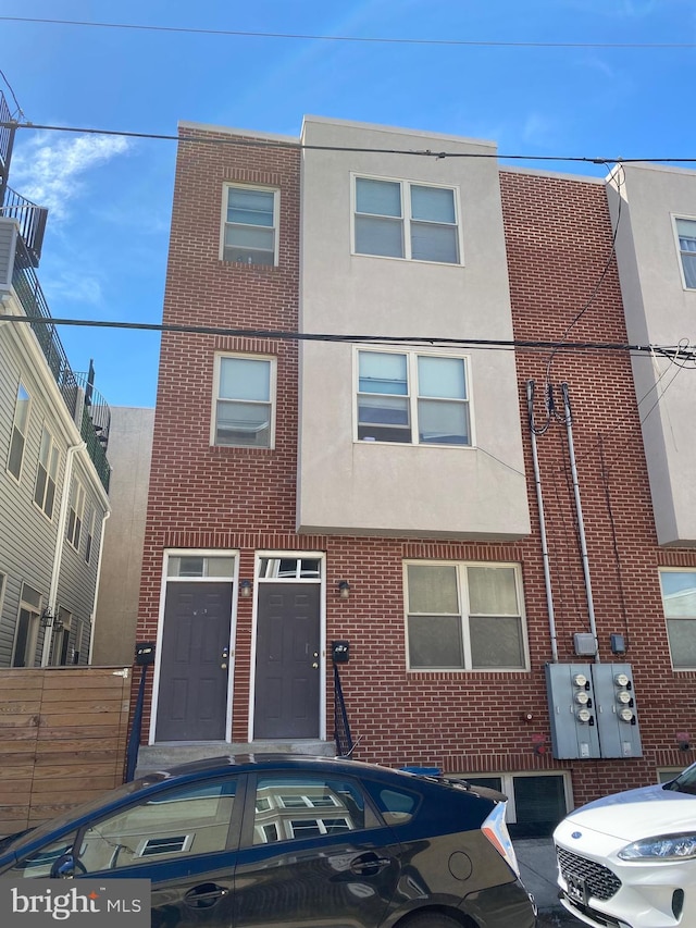 townhome / multi-family property featuring brick siding and stucco siding