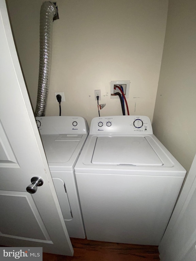 clothes washing area with laundry area, dark wood-type flooring, and separate washer and dryer