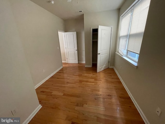 unfurnished bedroom with visible vents, light wood-type flooring, and baseboards