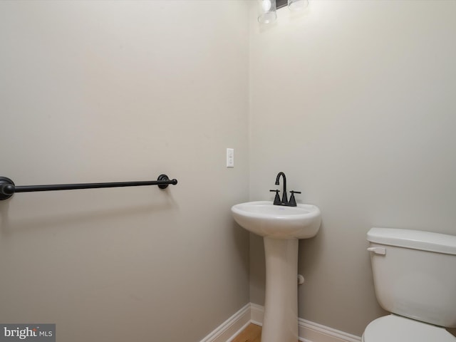 half bath with toilet and baseboards