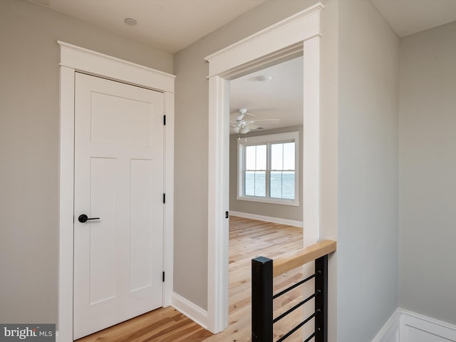 hallway featuring baseboards and light wood-type flooring