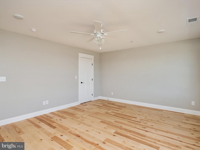 empty room featuring light wood-type flooring, baseboards, visible vents, and a ceiling fan