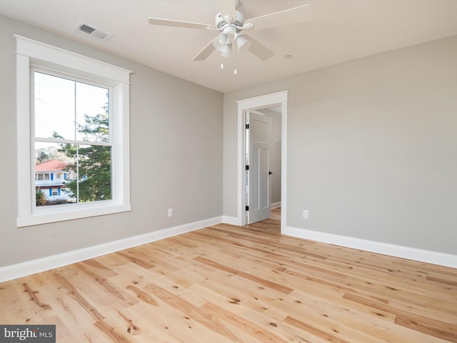 unfurnished room featuring light wood-type flooring, visible vents, baseboards, and a ceiling fan