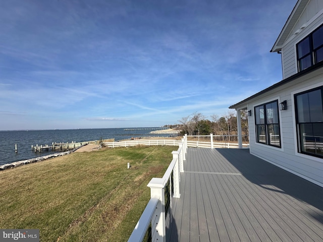 wooden deck featuring a lawn and a water view