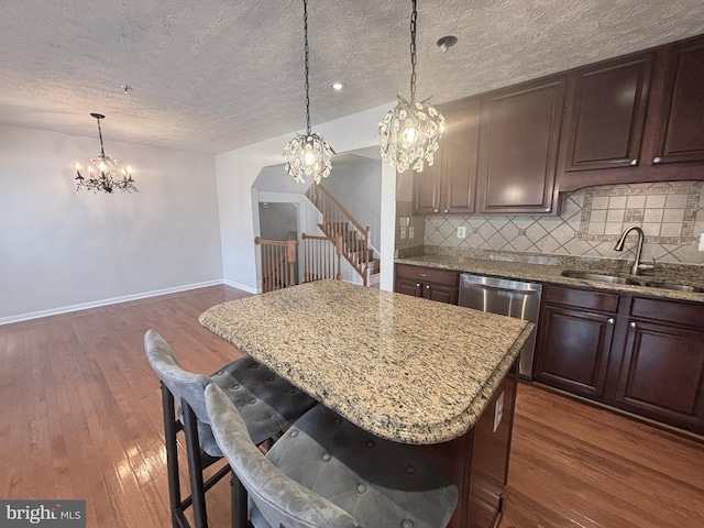 kitchen with a sink, tasteful backsplash, dishwasher, and dark wood-style floors