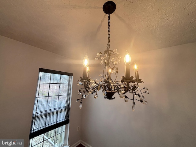 room details featuring a notable chandelier and a textured ceiling