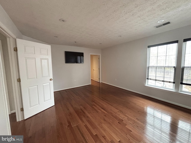 spare room with visible vents, baseboards, and wood finished floors