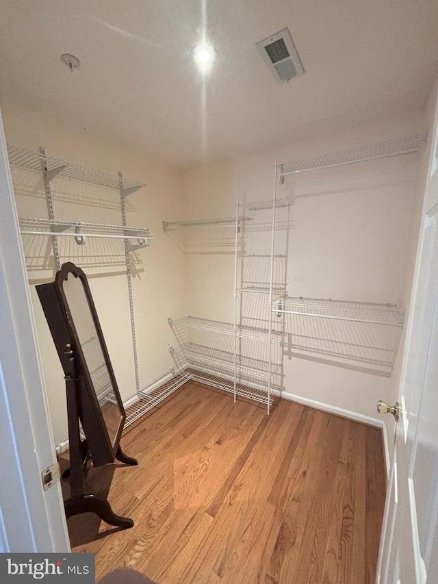 spacious closet featuring visible vents and wood finished floors