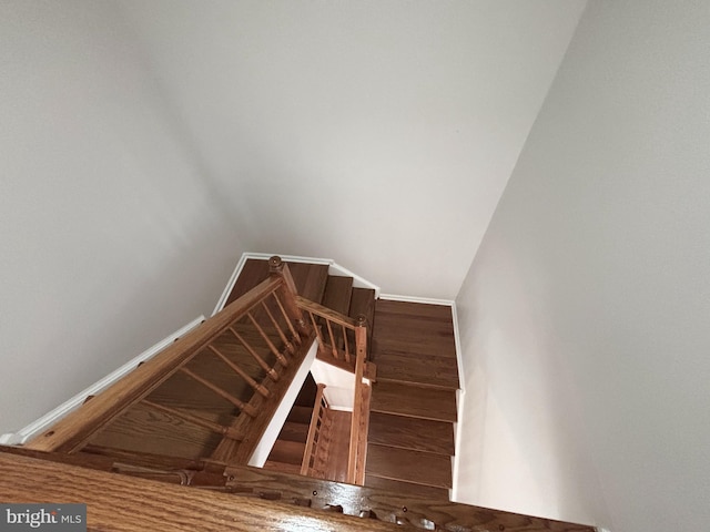 stairway featuring wood finished floors and baseboards